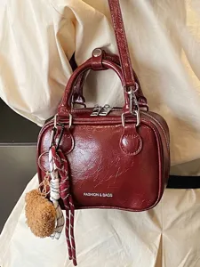 Retro weinrote glänzende kleine quadratische Handtasche mit Schultergurt und Bär