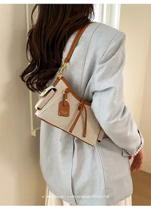 Vista detallada de un bolso de lona con elegantes adornos de cuero en un modelo retro