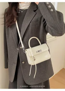 Detail shot of an elegant cream mini handbag with silver hardware and shoulder strap.