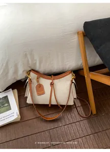 Detalle de un bolso de hombro de lona retro minimalista con ribetes de cuero marrón
