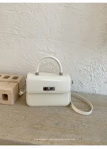 Close-up of elegant cream leather handbag with silver metallic turn-lock closure