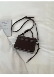 Sophisticated dark brown small square handbag with top handle and heart charm detail