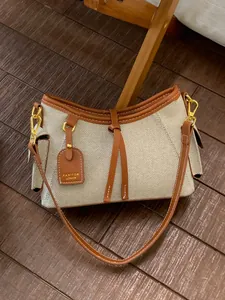 Elegante bolso de lona para mujer con ribete de cuero marrón y detalle de lazo decorativo