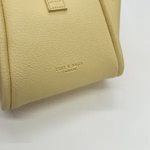 Vista detallada de la textura de cuero granulado premium en un bolso cubo amarillo