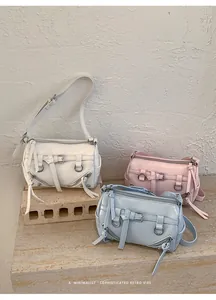Three stylish retro pillow bags in white pink and blue colors on stone ledge