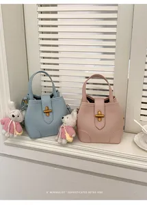 Borse a mano eleganti in blu e rosa con ciondoli a forma di coniglio sul davanzale