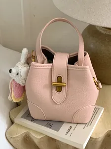 Elegante borsa a secchiello in pelle rosa con chiusura dorata e charm a coniglio