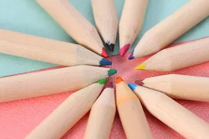 Macro view of colorful drawing pencil tips arranged in a circle on textured background