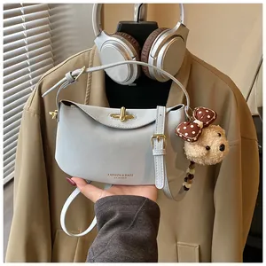Gedetailleerde weergave van lichtblauwe leren hobo-tas met een pluche beren-hanger