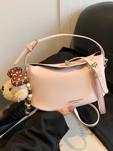 Elegante roze zadel tas met schattige teddybeer hanger en parelmoer riem detail
