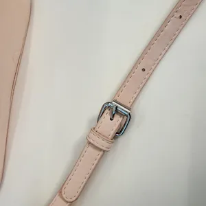 Dettaglio tracolla regolabile in pelle rosa chiaro con fibbia argentata per borsa
