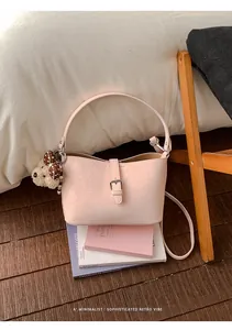 Elegante borsa a secchiello rosa da ufficio in pelle testurizzata con ciondolo a orsetto