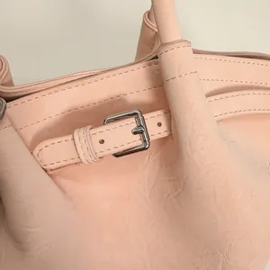 Dettaglio ravvicinato della fibbia in argento e cuciture fini su borsa tote in pelle rosa
