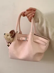 Elegante borsa a mano rosa minimalista con ciondolo a cucciolo e dettaglio cintura