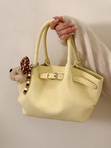 Elegante borsa shopping giallo pallido con ciondolo di peluche, moda chic a mano