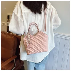Vue arrière d'une femme portant un sac bandoulière rose matelassé avec foulard en soie