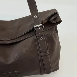 Detailansicht der braunen Vintage-Ledertragetasche mit verstellbarer Metallschnalle.