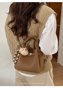 Chic brown leather bucket bag with retro charm shown on a model for autumn styling