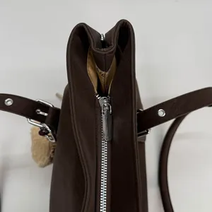 Detailaufnahme des silbernen Reißverschlusses dieser braunen Wildleder-Tragetasche