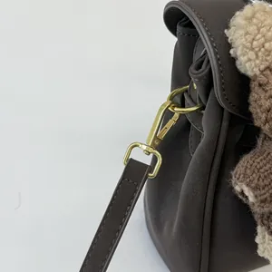 Détail du fermoir en métal doré et de la bandoulière en cuir d'un sac à bandoulière marron élégant