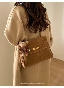 Sac à bandoulière en daim marron avec charm ours et fermoir doré sophistiqué