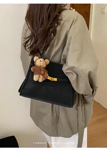 Vue en situation d'un sac à bandoulière noir minimaliste avec détails dorés élégants