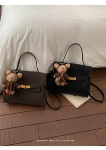 Sacs à main rétro minimalistes pour femmes avec breloques d'ours tricotées dans un décor intérieur