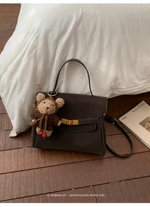 Chic sac à main marron vintage avec pendentif ours en peluche dans un décor douillet