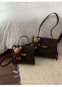 Détail de sacs à bandoulière marron vintage avec de mignons pendentifs ours en peluche