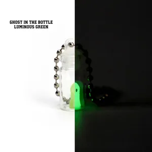 Detail view of luminous 3D printed ghost in a bottle keychain showing glow effect