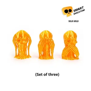 Macro view of 3D printed silk gold skull set in three classic see hear speak no evil poses