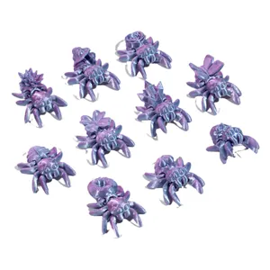 Figuras de arañas articuladas impresas en 3D iridiscentes con detalles de flores
