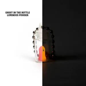 Detail view of luminous 3D printed ghost in a mini bottle keychain showing glow effect