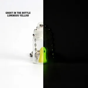 Macro view of 3D printed luminous ghost in a bottle keychain showing glow effect
