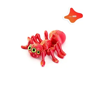 Detailed view of a 3D printed red articulated spider toy with multiple green eyes