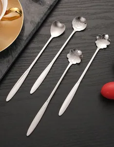 Close-up of four stainless steel long-handled stirring spoons with flower-shaped heads.