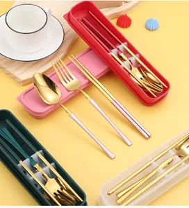 Detail of portable stainless steel cutlery set with golden finish in colorful storage boxes