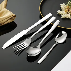 Set posate da 4 pezzi in acciaio inox con manici squadrati su fondo nero riflettente