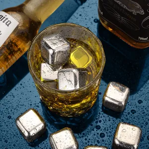 Wiederverwendbare Edelstahl-Eiswürfel in einem Whiskyglas mit Wassertropfen.