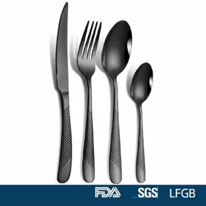 Detail of black stainless steel cutlery set with textured handles, includes knife, fork, and spoons