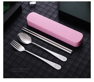 Macro view of portable stainless steel cutlery set with smiley face and pink storage case
