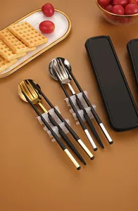 Close-up of portable stainless steel cutlery set with black handles and storage case
