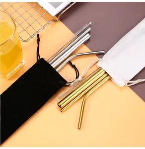 Close-up of reusable stainless steel straws in gold and silver with cleaning brushes