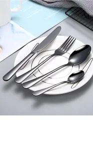 Premium black stainless steel cutlery set including knife and fork on a white patterned plate
