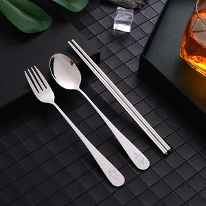 Portable stainless steel cutlery set featuring spoon, fork, and chopsticks with smile design