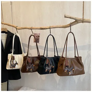 Display of four retro underarm bags in white, brown, and black with cute dog charms.