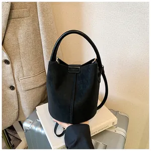 Detailansicht der schwarzen Retro-Beuteltasche mit Lederstruktur und Tragegriff