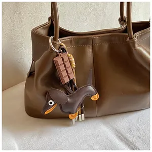 Close-up of brown vintage shoulder bag with cute dachshund and chocolate keychains