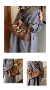 Vintage brown faux leather underarm shoulder bag styled with a grey oversized coat
