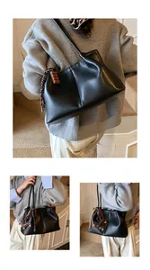 Detail view of black vintage underarm shoulder bag with model showing multiple angles.